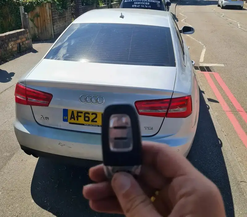 New Audi remote key held in front of a silver Audi saloon