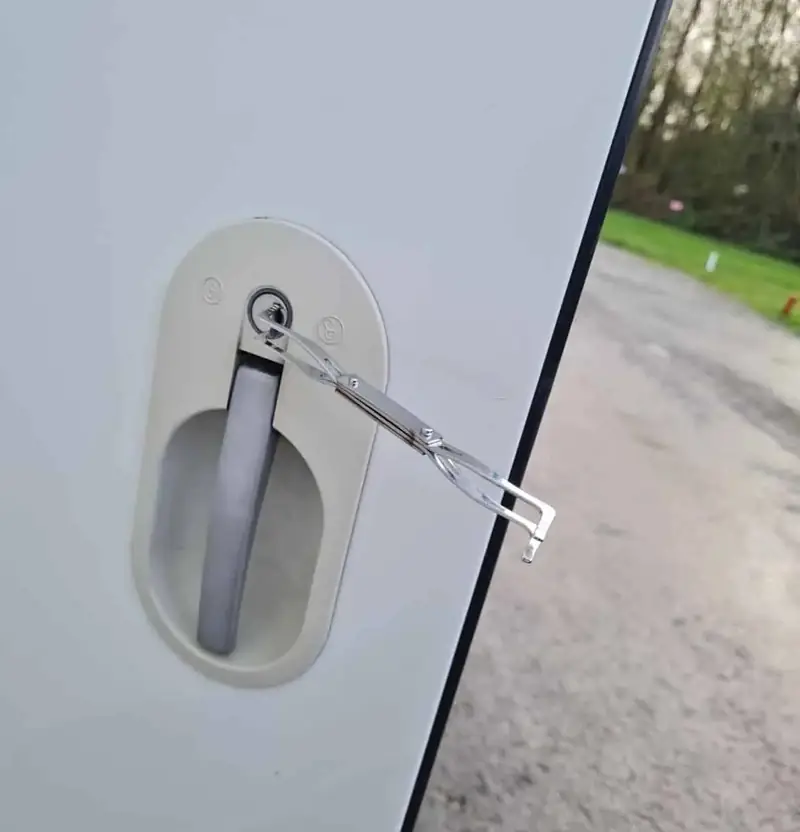 Entry tool in the lock of a white motorhome habitation door